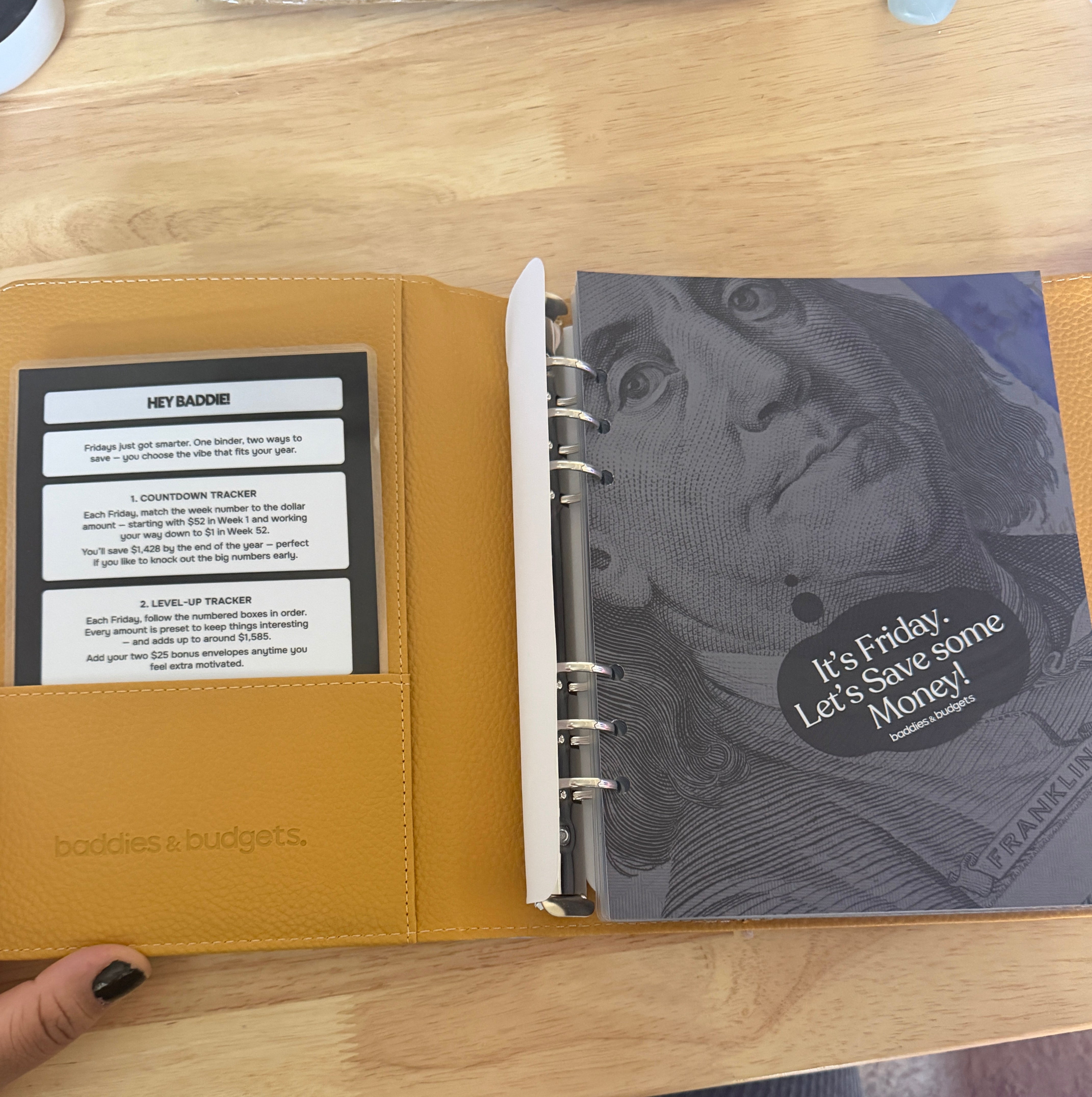 Pay Me On Friday silver holographic binder shown with cash and tracker