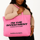 Curvy Black woman wearing gold jewelry and holding a bold statement canvas tote from Baddies & Budgets