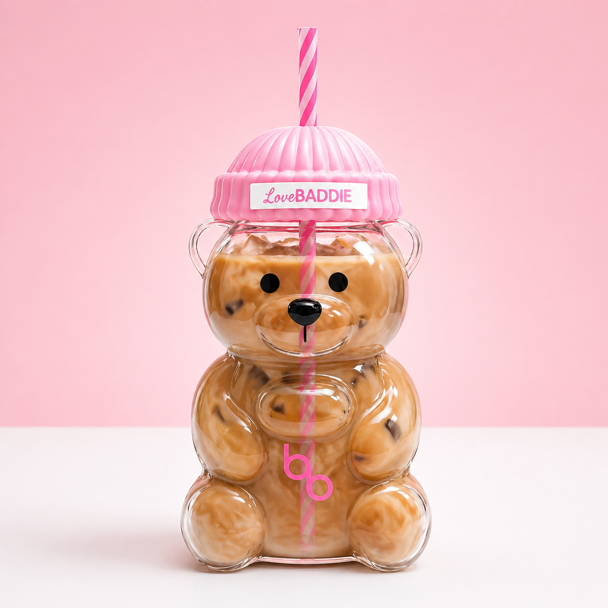 main shot — clear teddy bear cup with iced coffee, pink lid, pink striped straw, LoveBaddie label, pink background): "Baddies & Budgets 20oz teddy bear glass cup filled with iced coffee, pink quilted lid, pink striped straw, on white surface with pink background